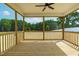 View of a spacious screened in porch with wood floors and a ceiling fan overlooking a wooded backyard at 4924 Zebulon Rd, Zebulon, NC 27597