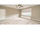 Spacious bedroom featuring neutral carpet, a ceiling fan, and ample natural light at 5305 Yorkville Ct, Holly Springs, NC 27540