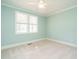Bright bedroom features neutral carpet, ceiling fan, a window, and clean, painted walls at 5305 Yorkville Ct, Holly Springs, NC 27540