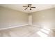 Large, carpeted bedroom featuring a ceiling fan and natural lighting at 5305 Yorkville Ct, Holly Springs, NC 27540