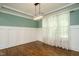 Formal dining room featuring hardwood floors, wainscoting, and modern chandelier at 5305 Yorkville Ct, Holly Springs, NC 27540