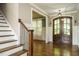 Elegant foyer with hardwood floors, staircase, and view into the formal dining room at 5305 Yorkville Ct, Holly Springs, NC 27540