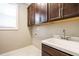 Well-lit laundry room with upper cabinets, sink and tile flooring at 5305 Yorkville Ct, Holly Springs, NC 27540
