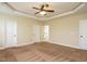 Bedroom featuring natural colored walls, tan carpet, ceiling fan, and multiple entryways at 5400 Falconton Ln, Raleigh, NC 27610