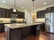 This kitchen features an island, stainless steel appliances, and dark cabinets at 5400 Falconton Ln, Raleigh, NC 27610