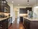 Spacious kitchen featuring stainless steel appliances, wood floors, and dark cabinetry at 5400 Falconton Ln, Raleigh, NC 27610