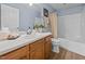 Well-lit bathroom with a shower-tub combo, modern vanity, and coordinating fixtures at 5561 Roan Mountain Pl, Raleigh, NC 27613