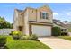 Charming two-story home with an attached garage and well-manicured lawn and colorful flower bed at 5561 Roan Mountain Pl, Raleigh, NC 27613