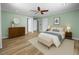 Tranquil main bedroom with fresh green walls, hardwood floors, and a ceiling fan at 5561 Roan Mountain Pl, Raleigh, NC 27613