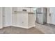Open kitchen space with stainless steel refrigerator, neutral tones, carpet and tile flooring creating functional separation at 5617 Tealbrook Dr, Raleigh, NC 27610