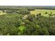 An aerial view shows the home's location in a beautiful, private wooded area at 5918 Efland Cedar Grove Rd, Cedar Grove, NC 27231