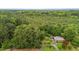 Aerial view of a brick home surrounded by lush forest, showcasing the property's privacy at 5918 Efland Cedar Grove Rd, Cedar Grove, NC 27231
