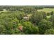 High angle shot from above of the property's main home surrounded by mature trees with a second home nearby at 5918 Efland Cedar Grove Rd, Cedar Grove, NC 27231