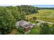 Charming brick home boasts metal roof, sunroom, & picturesque surroundings amidst lush greenery at 5918 Efland Cedar Grove Rd, Cedar Grove, NC 27231