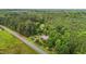 Overhead shot of property, showing a brick home amidst lush greenery, adjacent to a road and expansive forest at 5918 Efland Cedar Grove Rd, Cedar Grove, NC 27231