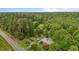 A high angle shot displaying a brick home nestled within lush greenery, near a road and sprawling forest at 5918 Efland Cedar Grove Rd, Cedar Grove, NC 27231