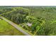 Expansive aerial view showcasing the property's generous lot size surrounded by lush trees and bordered by a road at 5918 Efland Cedar Grove Rd, Cedar Grove, NC 27231
