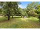 Lush backyard with mature trees and garden beds, offering a serene outdoor space at 5918 Efland Cedar Grove Rd, Cedar Grove, NC 27231