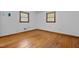 Cozy bedroom featuring hardwood floors, white walls, and two windows at 5918 Efland Cedar Grove Rd, Cedar Grove, NC 27231