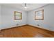 Bedroom features hardwood floors, ceiling fan, and two windows allowing natural light at 5918 Efland Cedar Grove Rd, Cedar Grove, NC 27231