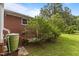 Brick home with a green rain barrel, window and landscaping on the side of the home at 5918 Efland Cedar Grove Rd, Cedar Grove, NC 27231