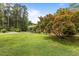 Well-manicured front yard with a vibrant maple tree enhancing the curb appeal of the brick home at 5918 Efland Cedar Grove Rd, Cedar Grove, NC 27231