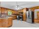 Eat-in Kitchen with knotty pine cabinetry, stainless appliances, & tile flooring at 5918 Efland Cedar Grove Rd, Cedar Grove, NC 27231