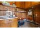 Utility room with wood paneled walls and sink with upper and lower cabinets at 5918 Efland Cedar Grove Rd, Cedar Grove, NC 27231