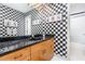 Unique bathroom with checkered walls, black marble countertop and a framed mirror detail at 6 Womble Cir, Durham, NC 27705
