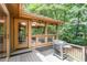 Outdoor deck with a grill, offering serene views of a lush backyard and sunroom at 6 Womble Cir, Durham, NC 27705