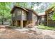Home exterior featuring a raised foundation, wood siding, and lush landscaping in a wooded area at 6 Womble Cir, Durham, NC 27705