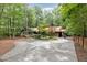 Single story home surrounded by lush greenery, a long concrete driveway, and wooded lot at 6 Womble Cir, Durham, NC 27705