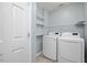 Well-lit laundry room with washer, dryer, and shelving at 615 Southshore Pkwy, Durham, NC 27703