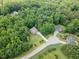 Aerial view of home surrounded by dense lush trees and landscaping at 6717 Country Hollows Ln, Holly Springs, NC 27540