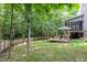 Spacious backyard with a seating area, surrounded by mature trees and a privacy fence at 6717 Country Hollows Ln, Holly Springs, NC 27540