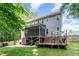 Backyard view of two-story home with deck and screened-in porch at 6717 Country Hollows Ln, Holly Springs, NC 27540