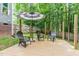 Relaxing backyard deck space with umbrella and three Adirondack chairs at 6717 Country Hollows Ln, Holly Springs, NC 27540