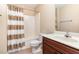 Well-lit bathroom with a shower-tub combo, and vanity sink with a chocolate-brown cabinet at 6717 Country Hollows Ln, Holly Springs, NC 27540