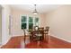 Dining room with a wood table, chairs, and a window, featuring wood flooring at 6717 Country Hollows Ln, Holly Springs, NC 27540