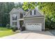 Charming gray two-story home with a two-car garage, landscaped yard, and inviting curb appeal at 6717 Country Hollows Ln, Holly Springs, NC 27540