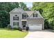 Charming two-story home features a gray siding, well-maintained lawn, and an attached two-car garage at 6717 Country Hollows Ln, Holly Springs, NC 27540