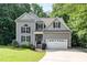Charming gray two-story home with a two-car garage, landscaped yard, and inviting curb appeal at 6717 Country Hollows Ln, Holly Springs, NC 27540