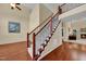 Inviting foyer with hardwood floors, staircase and wrought iron railing leading to a cozy living room with fireplace at 6717 Country Hollows Ln, Holly Springs, NC 27540