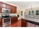 Open kitchen boasts stainless steel appliances and opens to living area with fireplace at 6717 Country Hollows Ln, Holly Springs, NC 27540