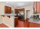 Well-lit kitchen with stainless steel appliances, granite countertops, and wood cabinets at 6717 Country Hollows Ln, Holly Springs, NC 27540