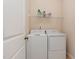 Well-equipped laundry room with a washer, a dryer, and shelving at 6717 Country Hollows Ln, Holly Springs, NC 27540