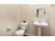 Elegant powder room with a pedestal sink and decorative mirror at 6717 Country Hollows Ln, Holly Springs, NC 27540