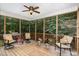 Relaxing screened porch with comfortable seating, ceiling fan, and wooded views at 6717 Country Hollows Ln, Holly Springs, NC 27540