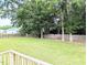 Large backyard featuring lush green lawn, tall trees, and a wood privacy fence at 70 Dexterfield Dr, Fuquay Varina, NC 27526