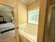 Bright bathroom with a large tub, window, and doorway leading to the bedroom at 70 Dexterfield Dr, Fuquay Varina, NC 27526